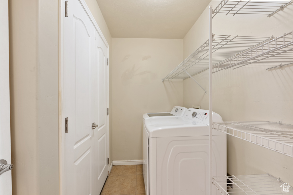 Washroom featuring light tile patterned floors and independent washer and dryer