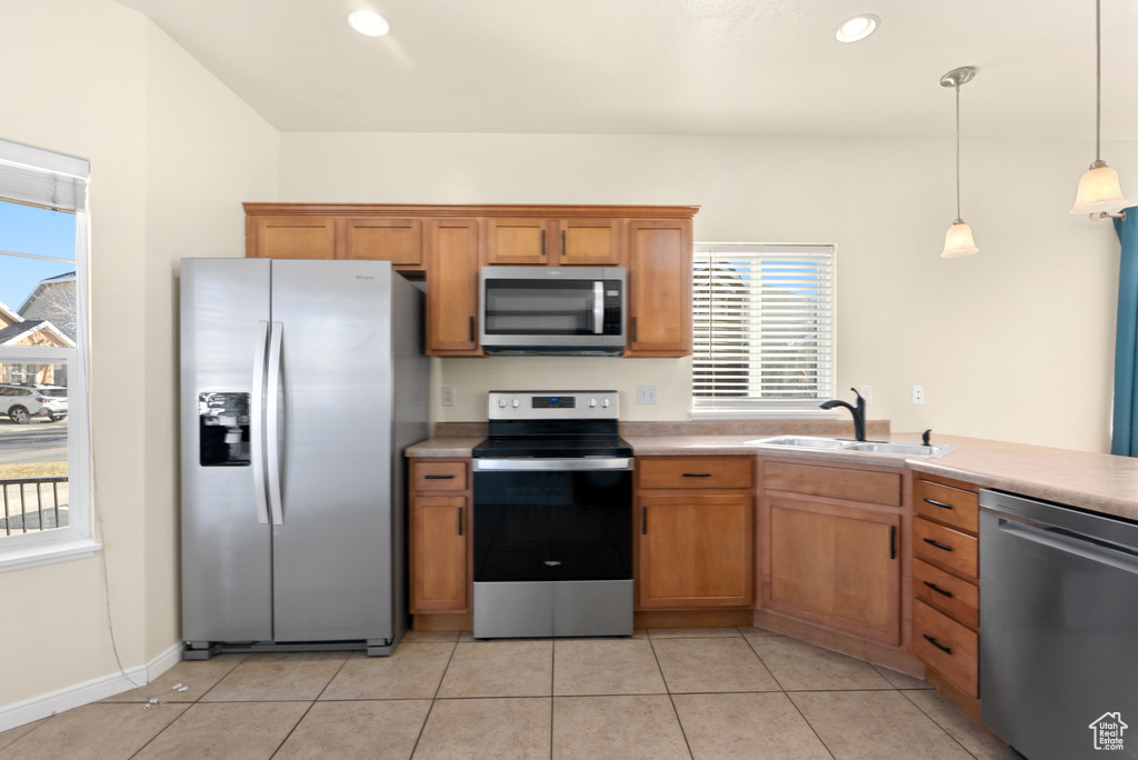 Kitchen featuring hanging light fixtures, a healthy amount of sunlight, stainless steel appliances, and sink