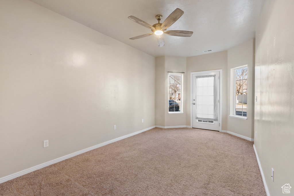 Carpeted spare room with ceiling fan