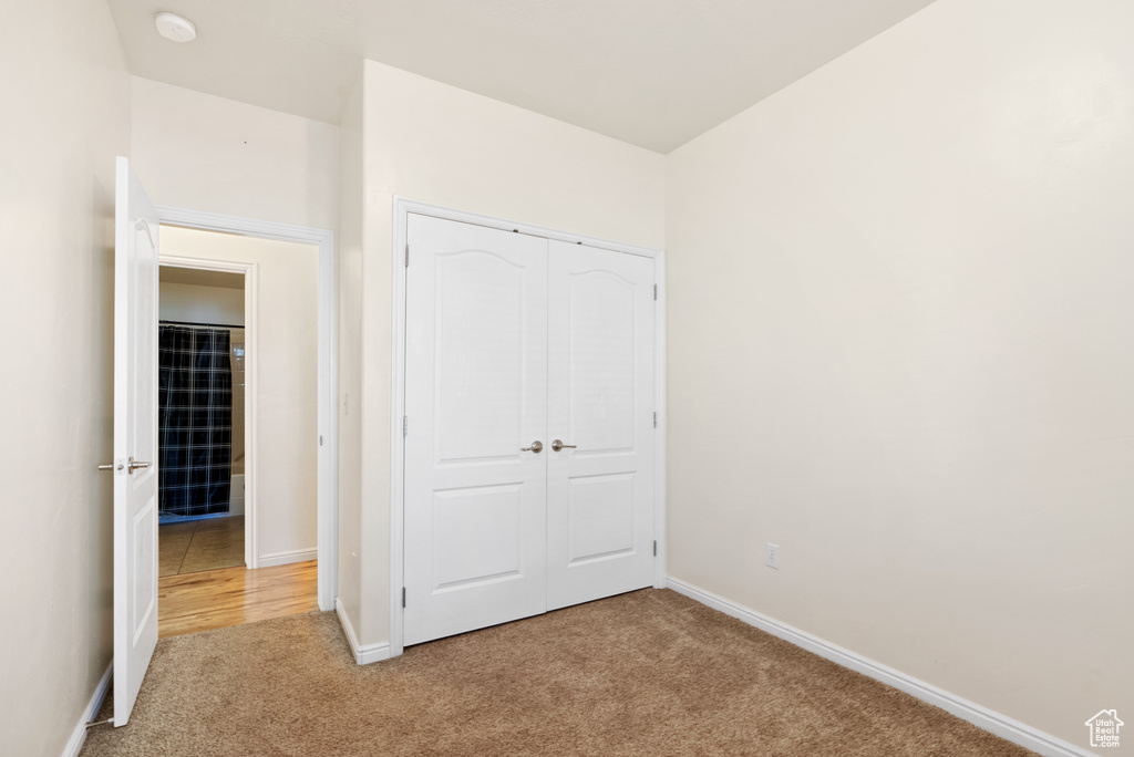 Unfurnished bedroom with a closet and light colored carpet