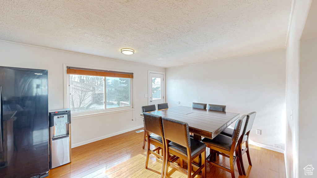 Dining room featuring light hardwood / wood-style flooring and a textured ceiling