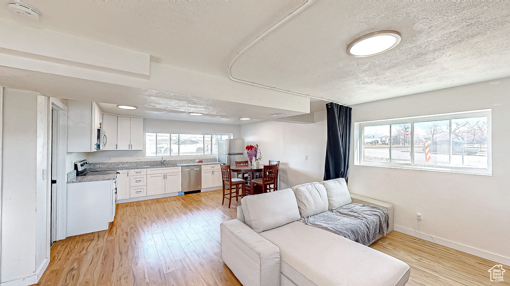 Living room featuring light hardwood / wood-style flooring and a textured ceiling