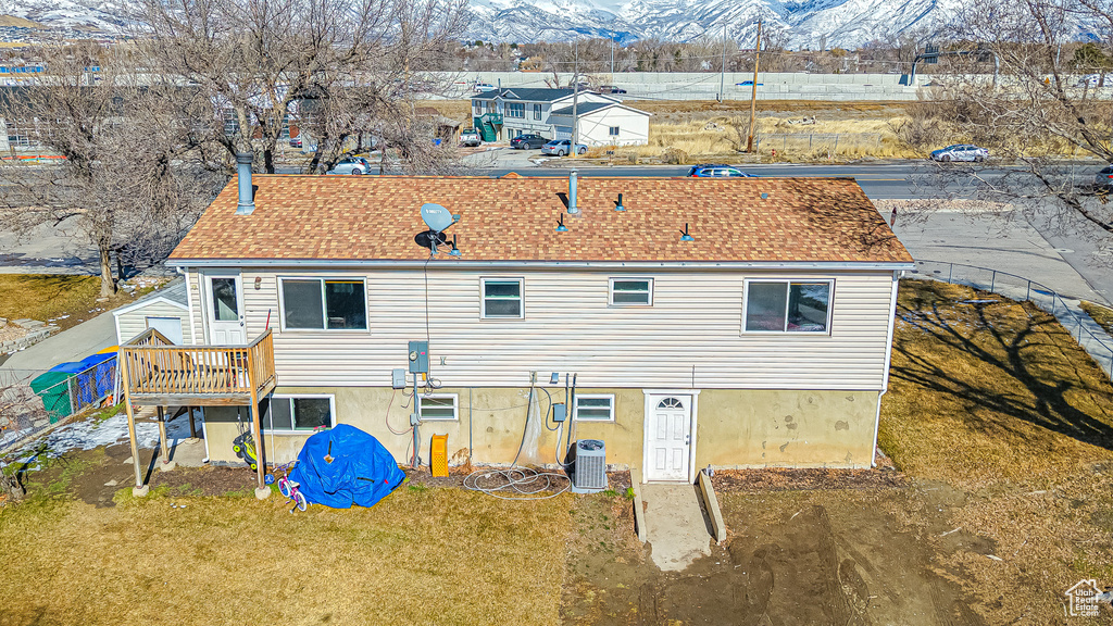 Back of property featuring central AC unit, a yard, and a deck with mountain view