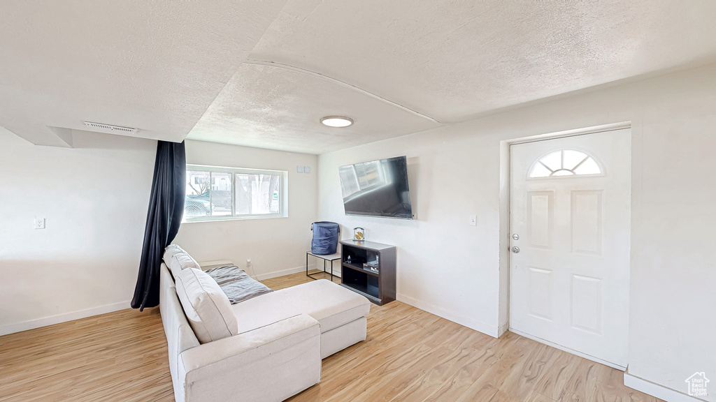 Living room featuring light hardwood / wood-style floors and a textured ceiling