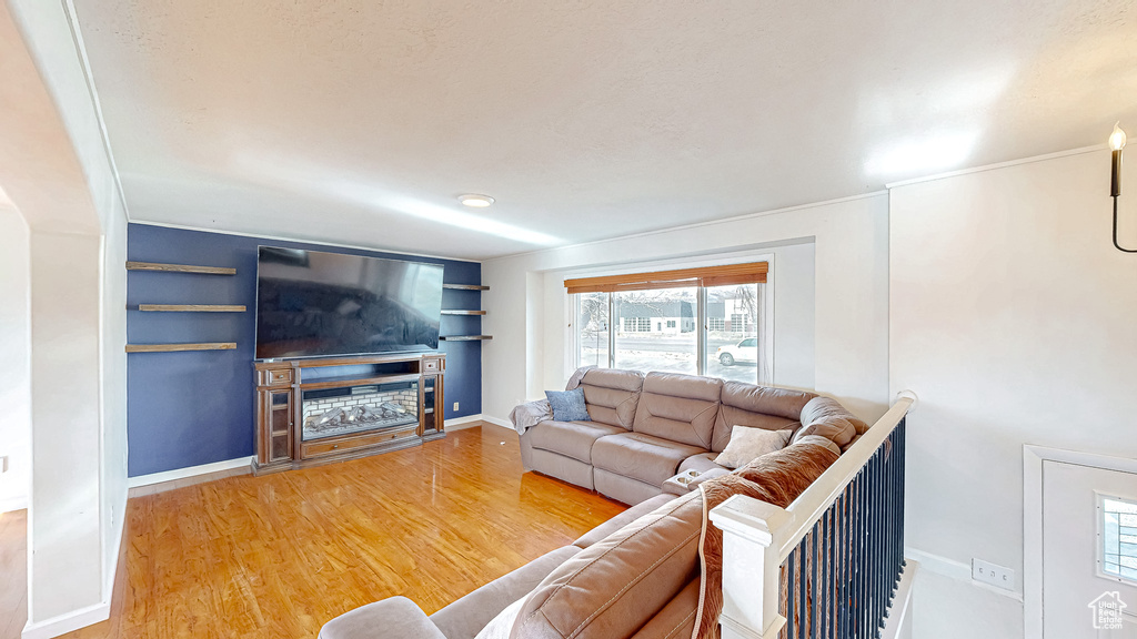 Living room featuring a fireplace, wood-type flooring, and built in features