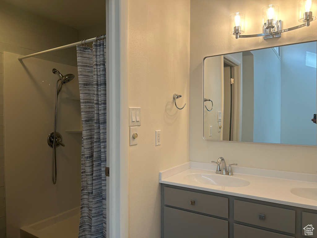 Full bathroom featuring double vanity, curtained shower, and a sink