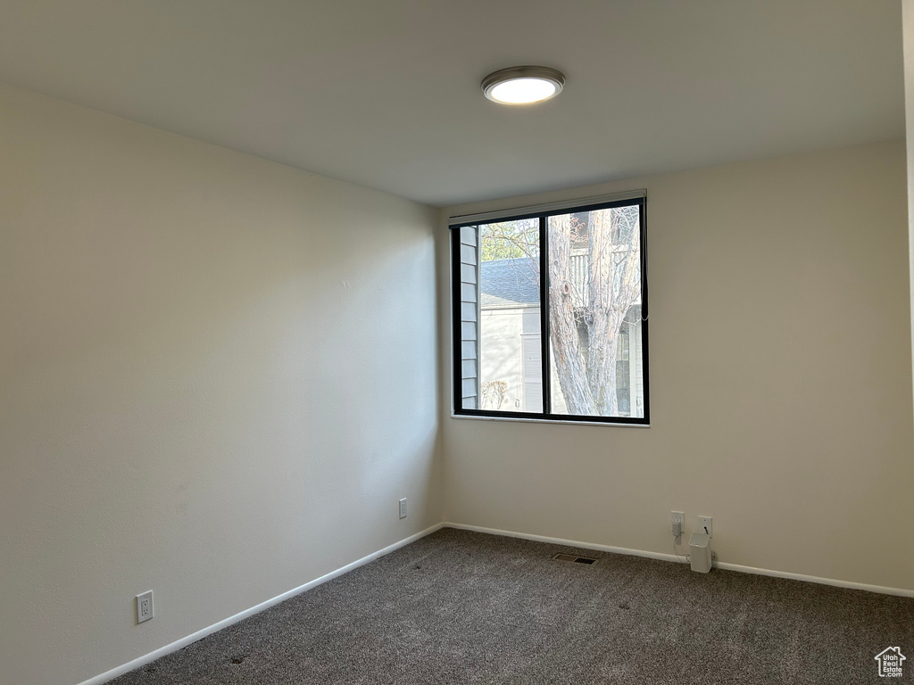 Spare room with dark carpet