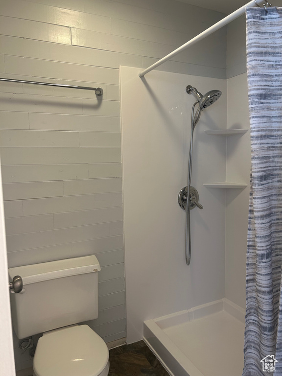 Full bath featuring toilet and a shower stall