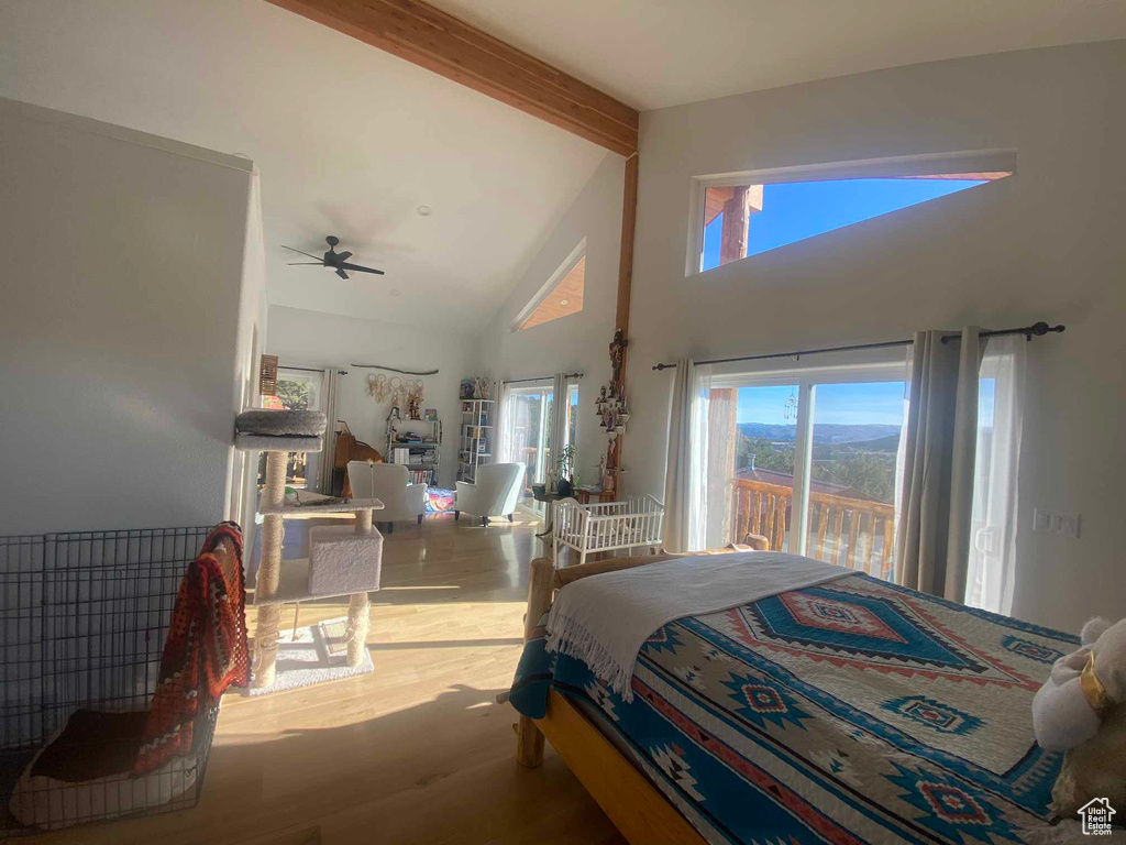 Bedroom featuring high vaulted ceiling, beamed ceiling, wood finished floors, and access to exterior