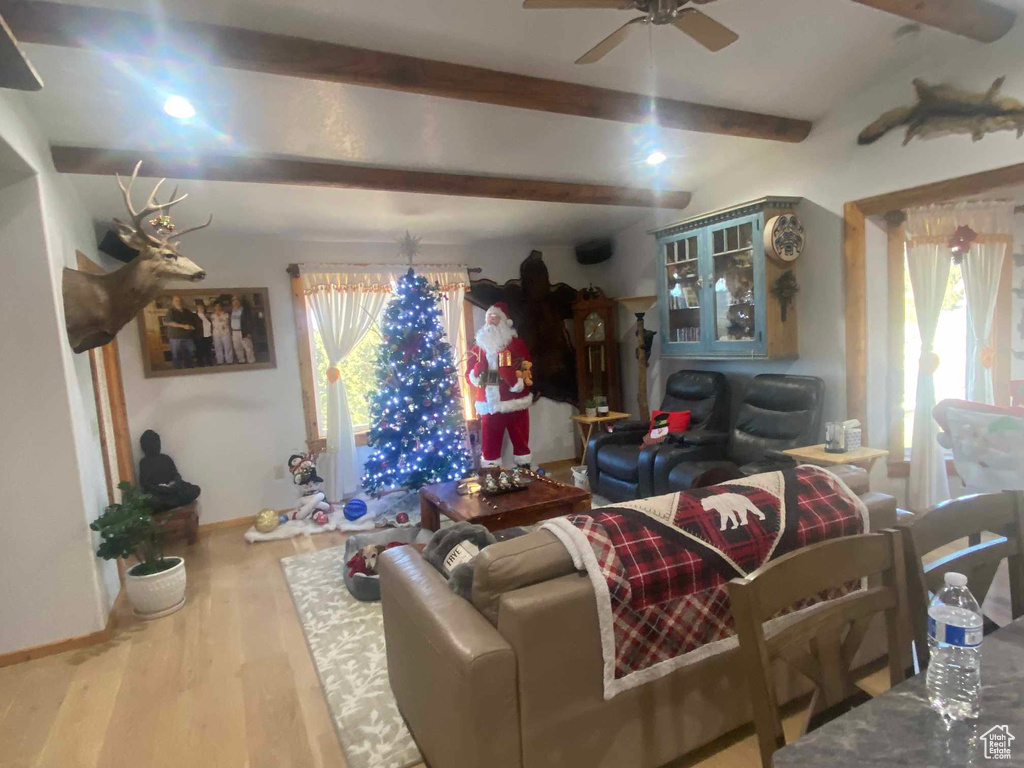 Living area featuring plenty of natural light, wood finished floors, beam ceiling, and baseboards