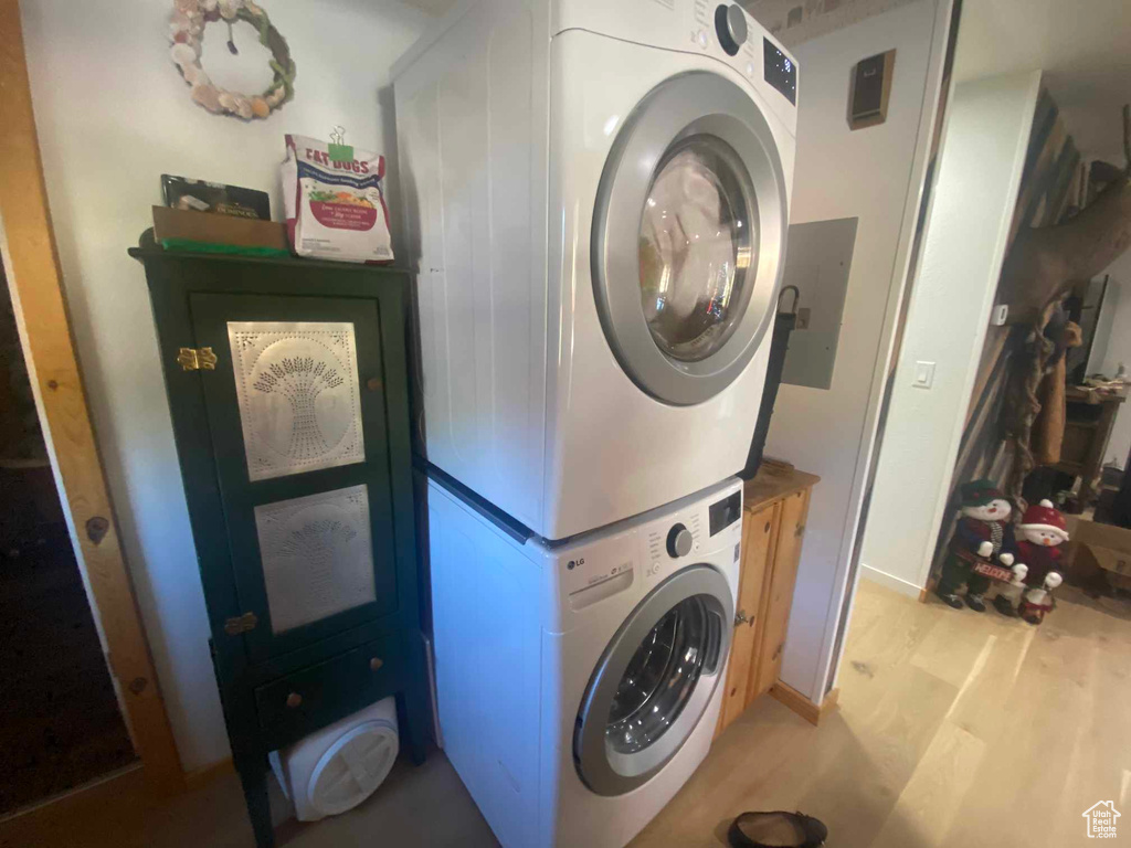 Laundry area featuring stacked washing maching and dryer, laundry area, and light wood-style floors