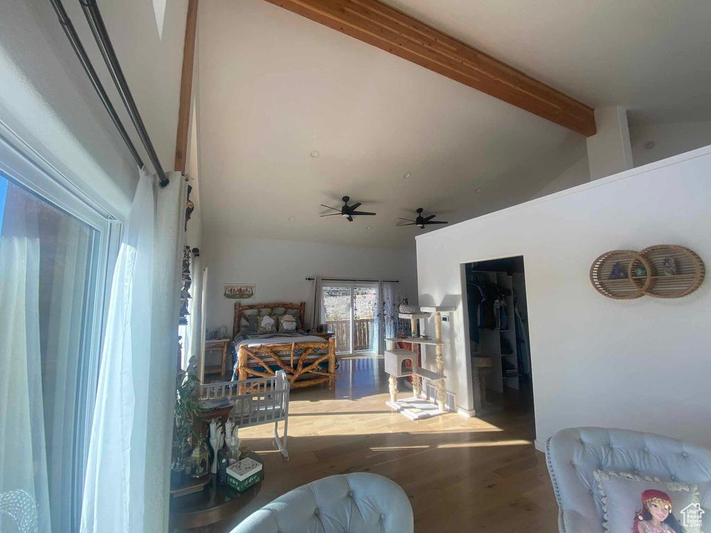 Living area with vaulted ceiling with beams, ceiling fan, and wood finished floors