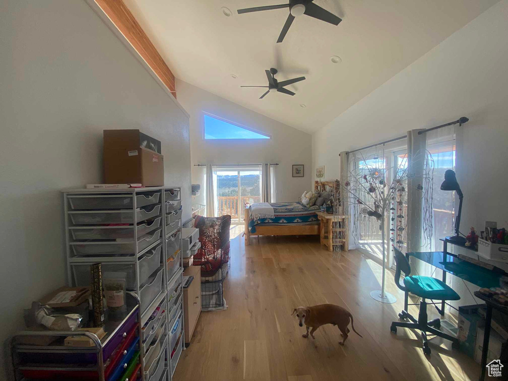 Bedroom featuring light wood-type flooring, access to exterior, high vaulted ceiling, and a ceiling fan