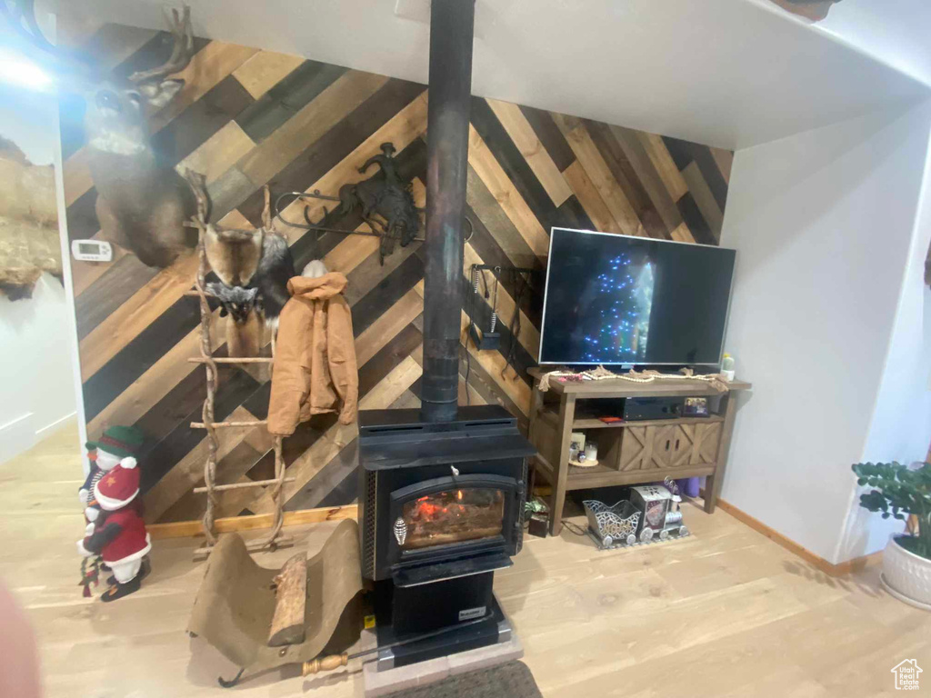 Interior details with wood finished floors, a wood stove, and baseboards