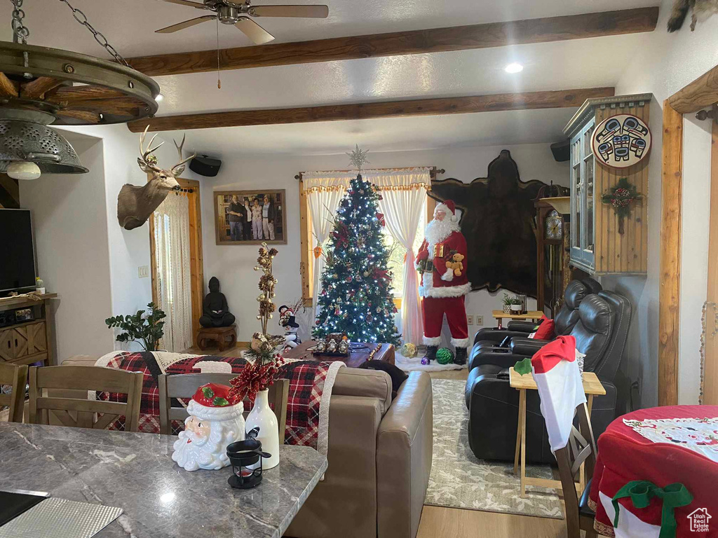 Dining area featuring ceiling fan, beamed ceiling, and wood finished floors