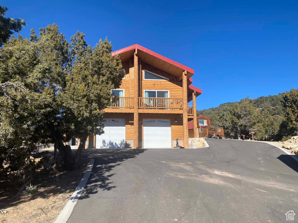 View of side of property with driveway and an attached garage