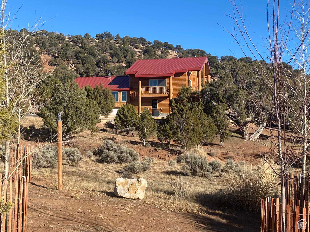 Exterior space with a balcony, faux log siding, and metal roof