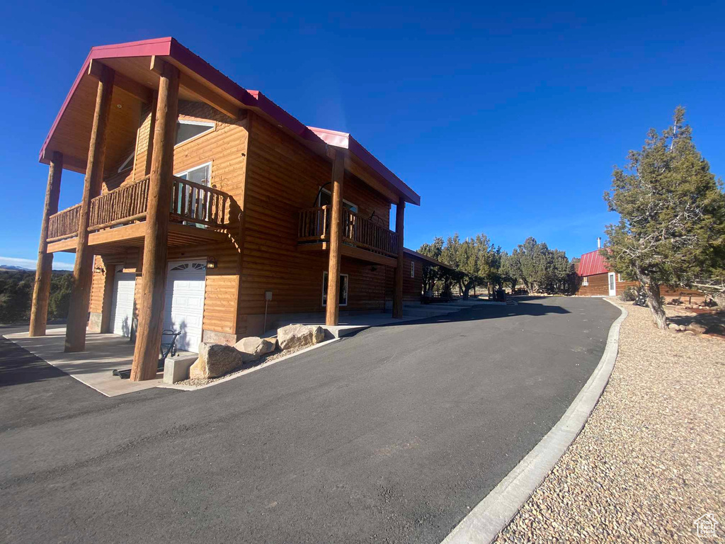 View of side of property featuring log veneer siding and an attached garage