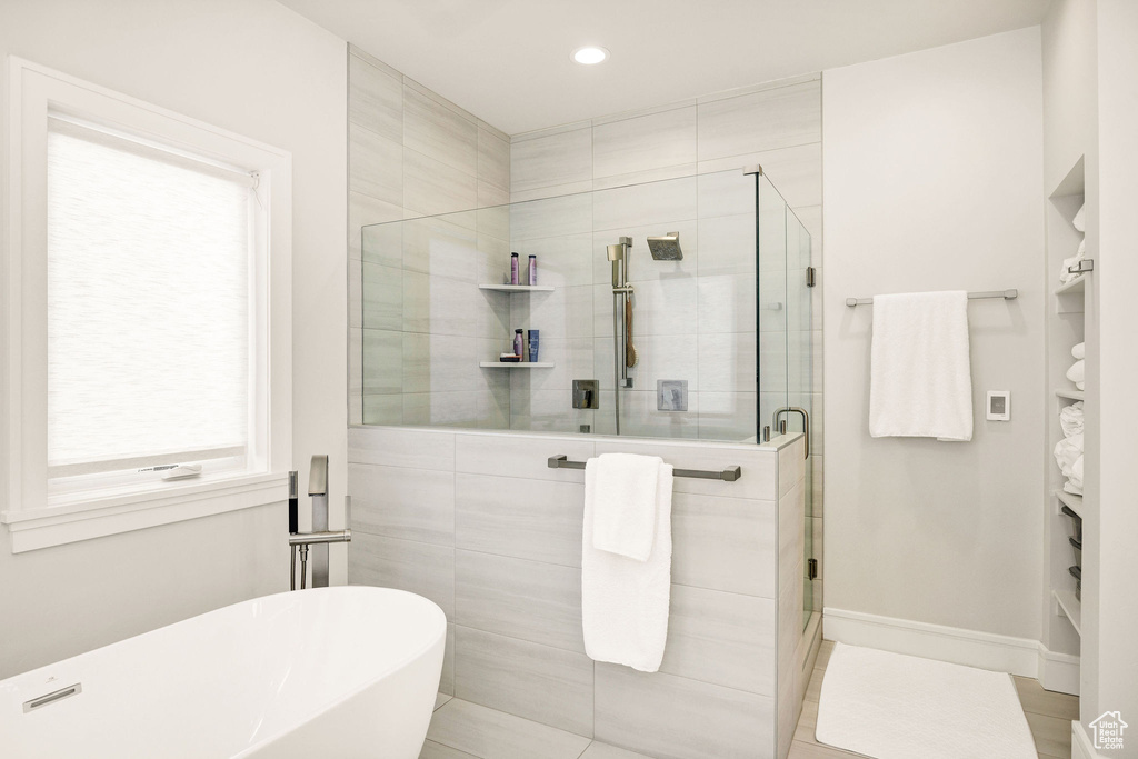 Bathroom with independent shower and bath and tile patterned flooring