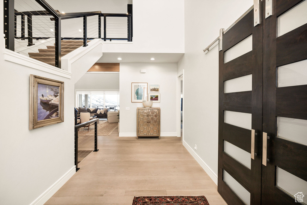 Corridor featuring a high ceiling and light wood-type flooring