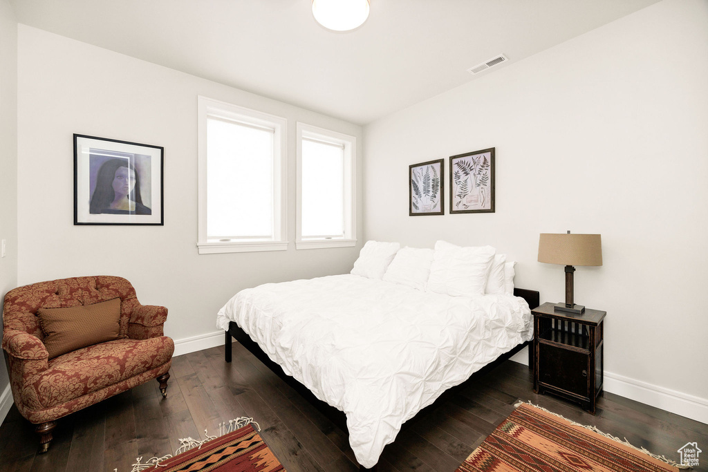 Bedroom with dark hardwood / wood-style flooring