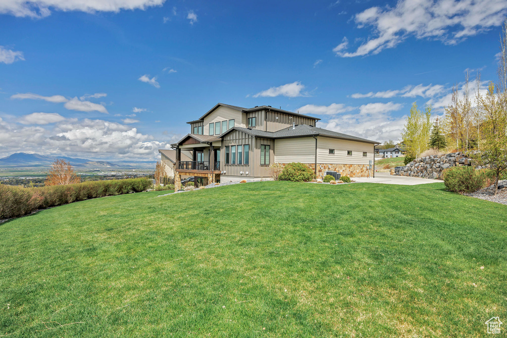 View of front of property with board and batten siding and a front yard