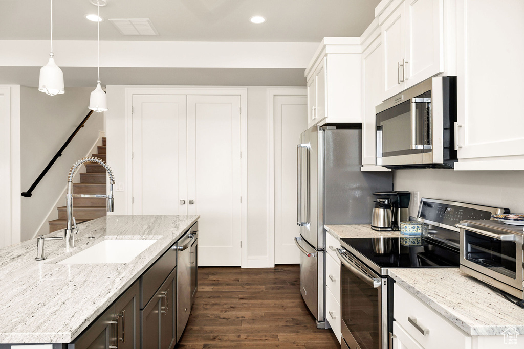 Kitchen featuring sink, appliances with stainless steel finishes, and white cabinets