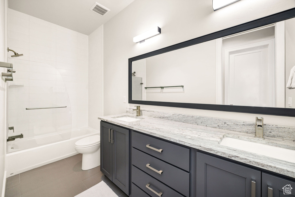 Full bathroom with toilet, vanity, shower / washtub combination, and tile patterned floors