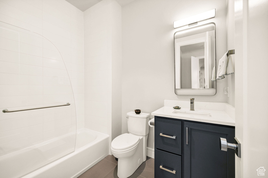 Full bathroom with tile patterned floors, vanity, shower / bathtub combination, and toilet