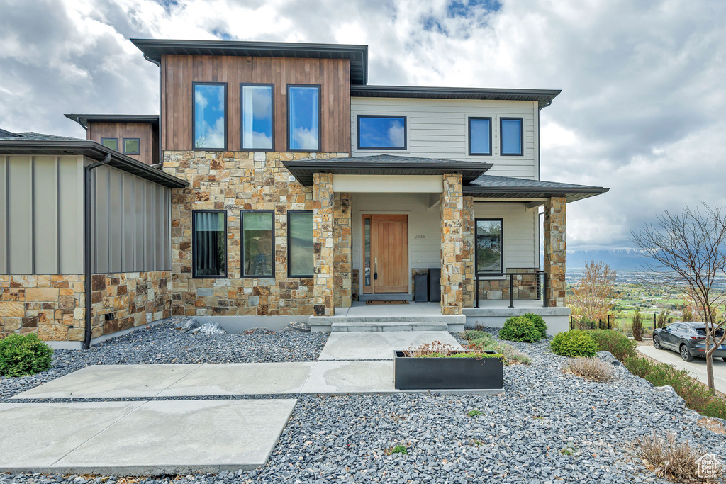 Modern home with a porch and stone siding
