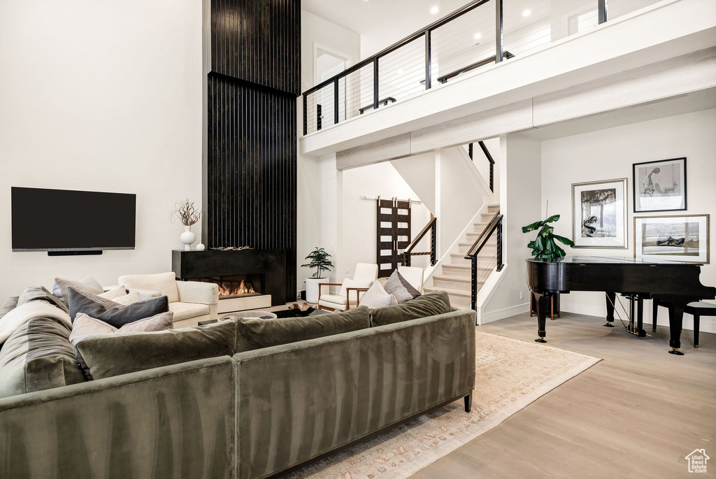 Living room featuring light wood-type flooring and a high ceiling
