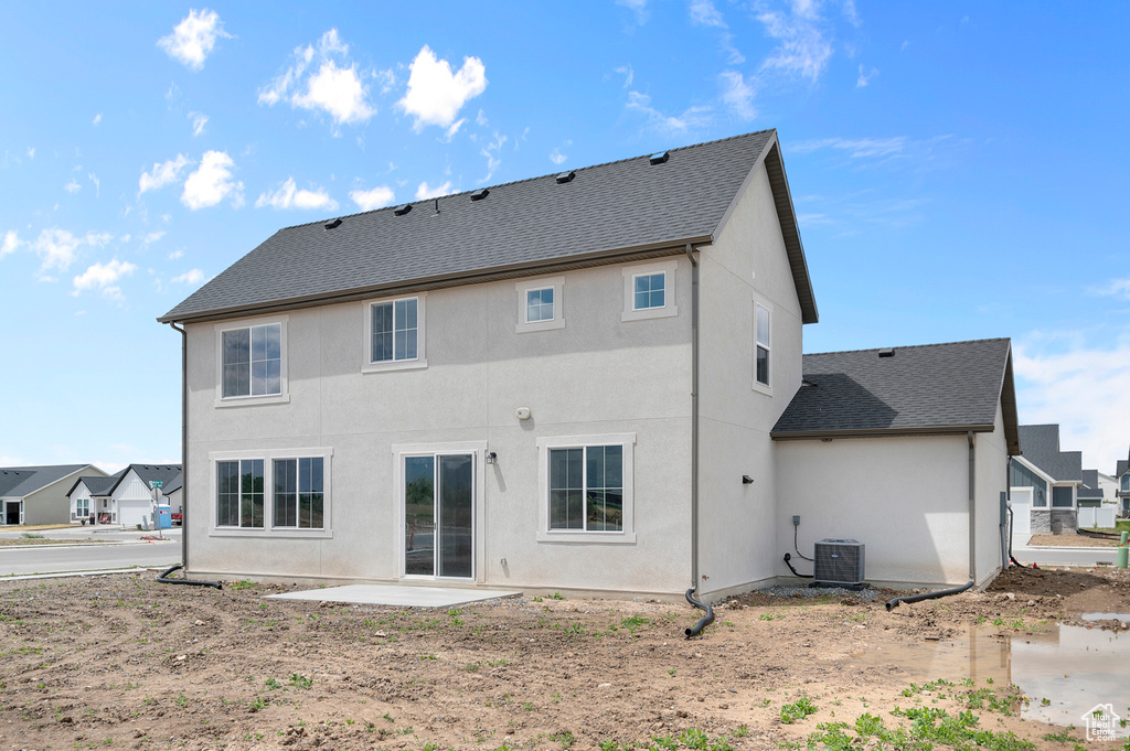 Back of house with a patio, central AC unit, stucco siding, and a shingled roof