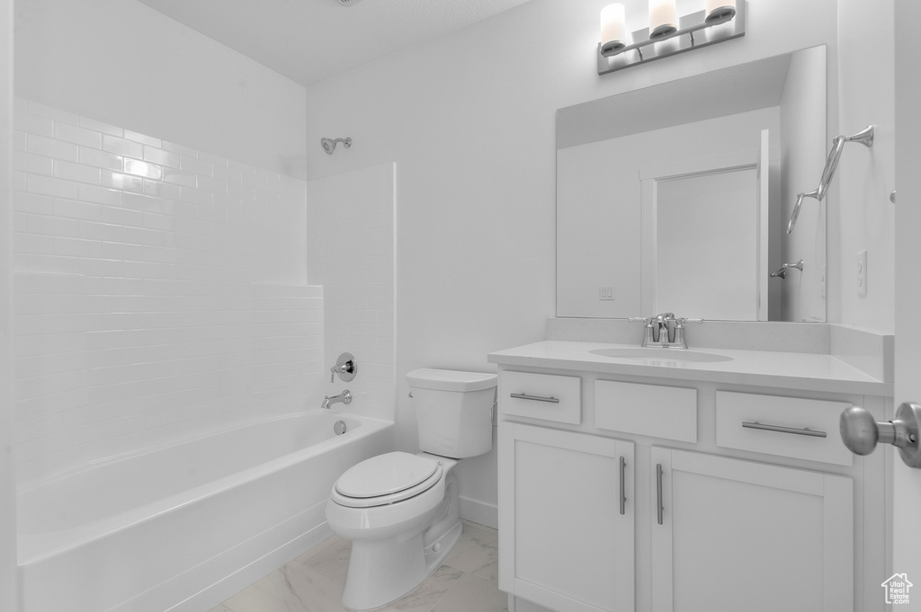 Full bath featuring toilet, marble finish flooring, vanity, and shower / washtub combination
