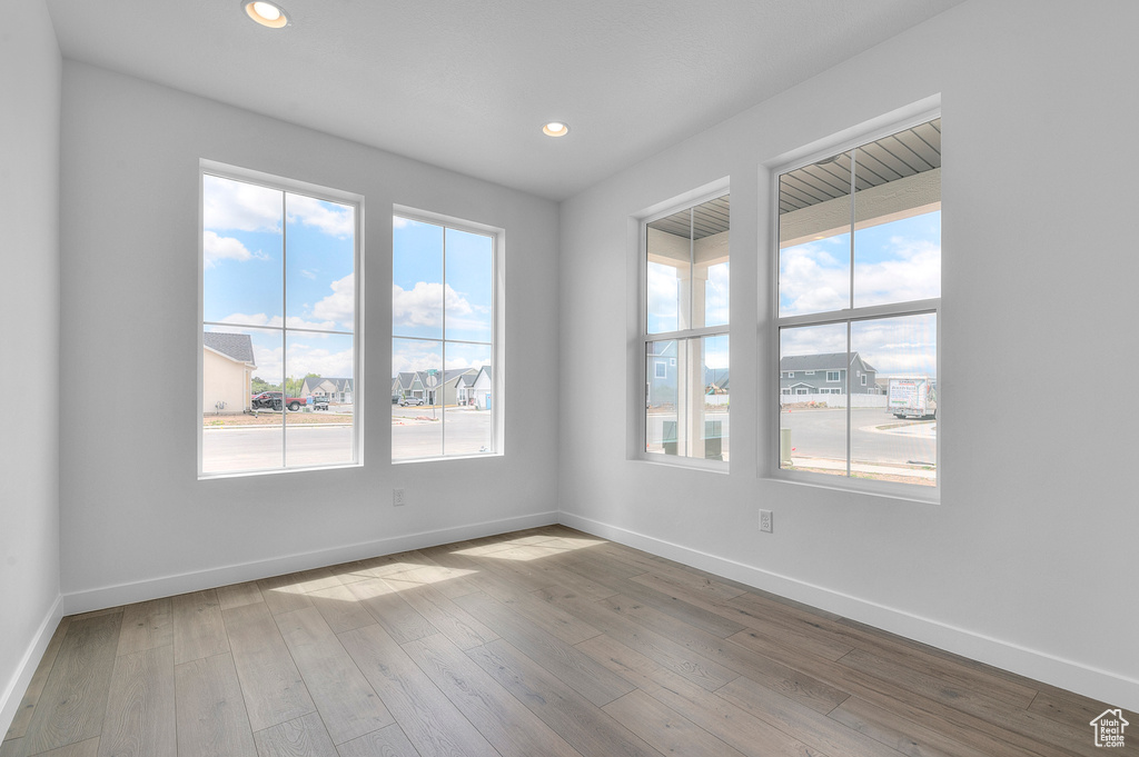 Empty room with baseboards, wood-type flooring, and recessed lighting
