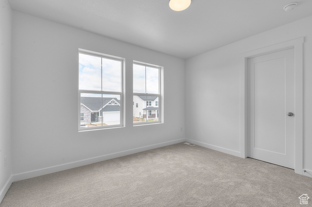 Unfurnished room featuring carpet, baseboards, and a smoke detector