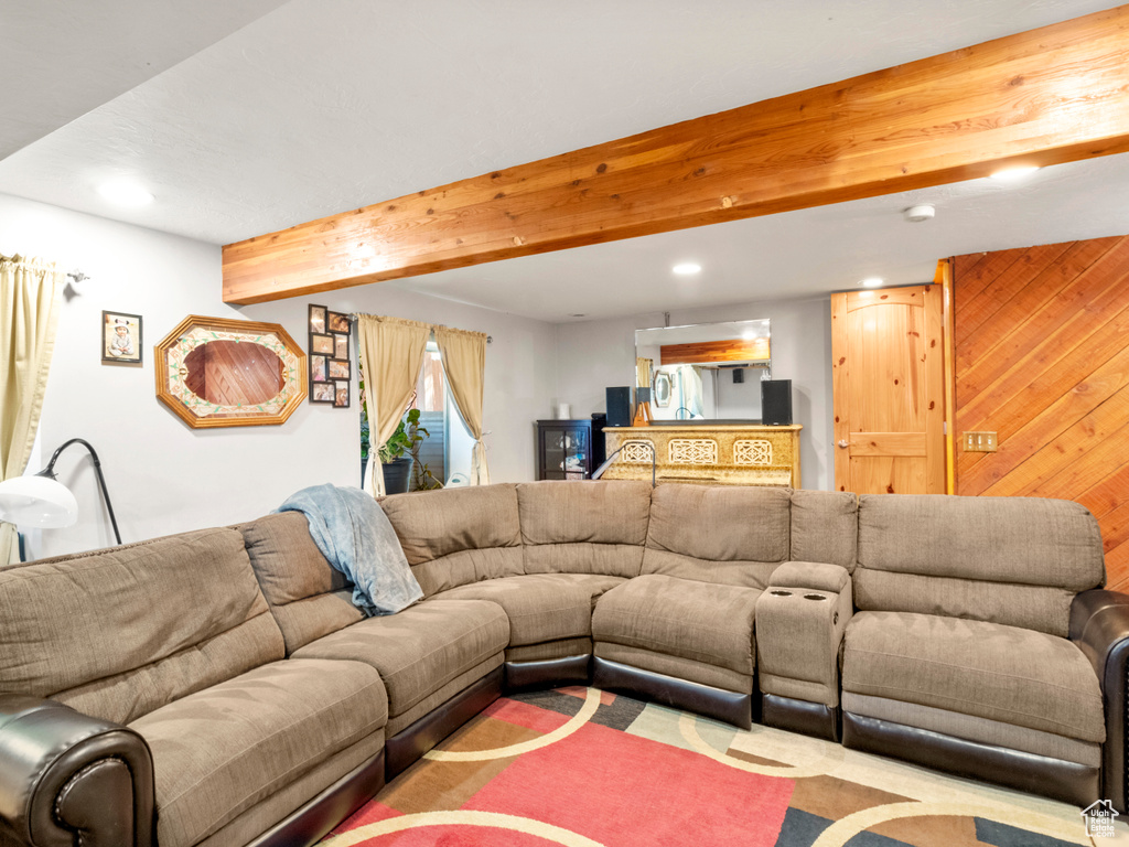 Living room featuring beamed ceiling and wooden walls