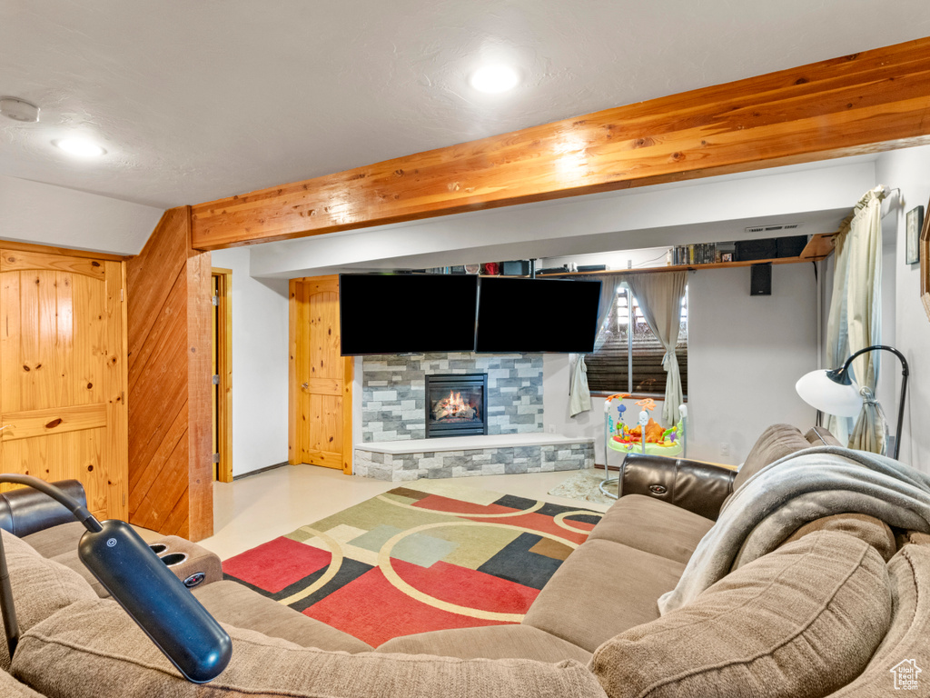 Living room with a stone fireplace and beam ceiling