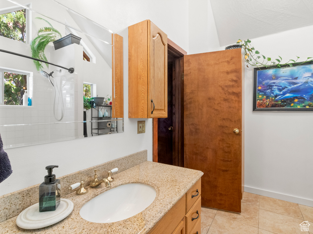 Bathroom with vanity, tile patterned flooring, and a shower