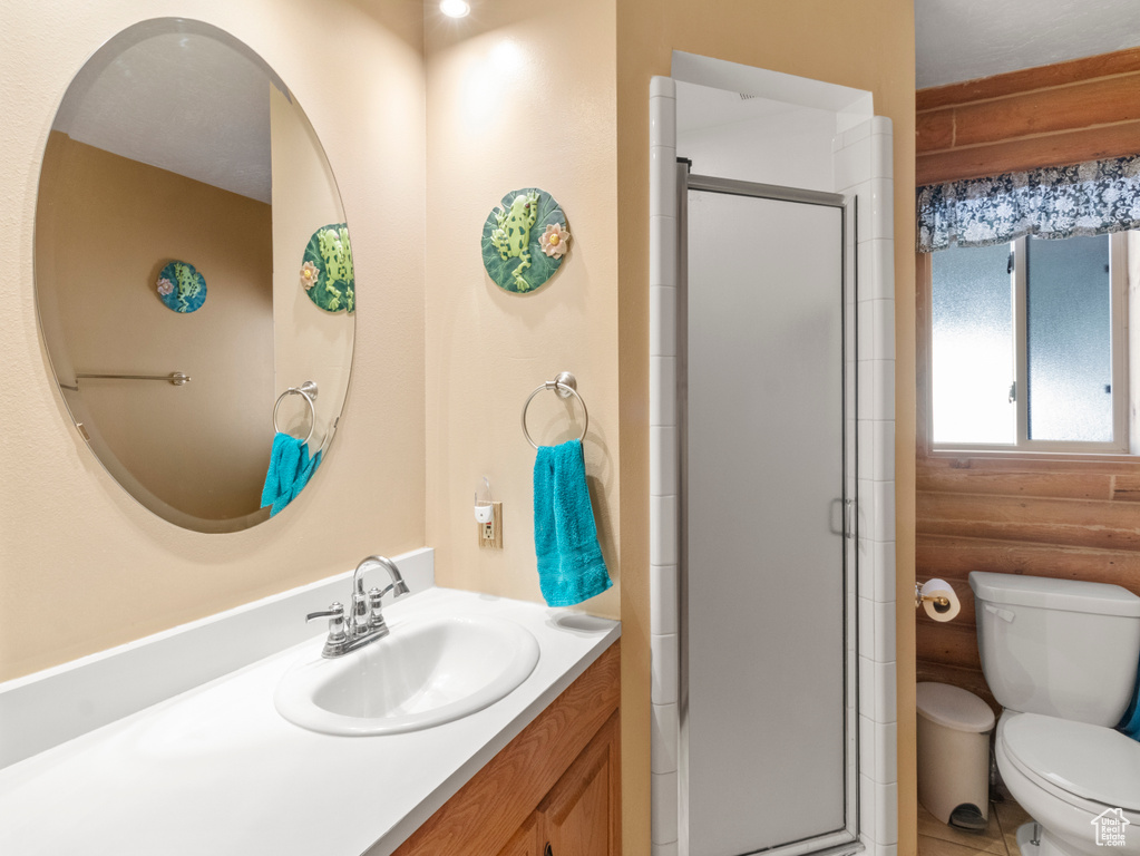 Bathroom with toilet, vanity, walk in shower, and rustic walls