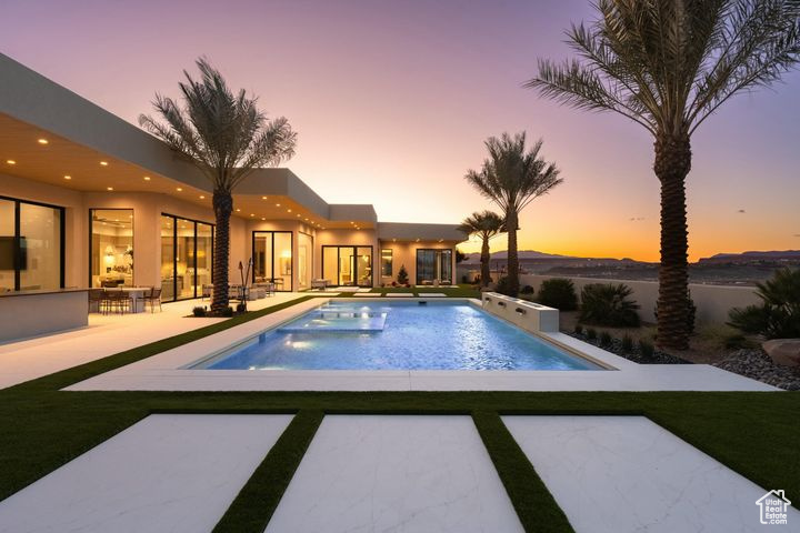 Pool at dusk with a patio