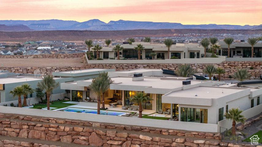Back house at dusk with a mountain view and a patio