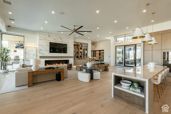 Living room featuring a fireplace, ceiling fan, and light hardwood / wood-style floors