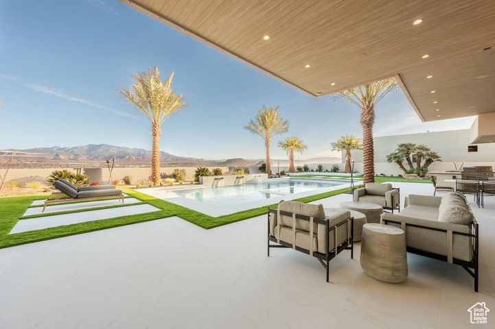 View of patio featuring an outdoor living space, a mountain view, and a fenced in pool