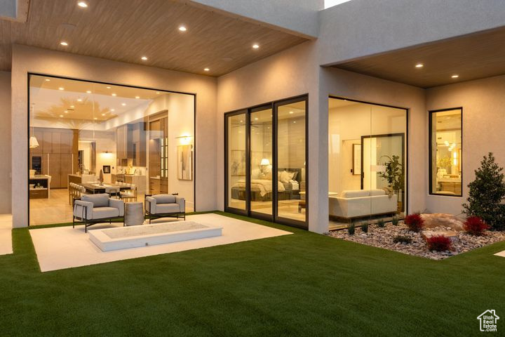 Rear view of house with an outdoor hangout area, a patio, and a lawn