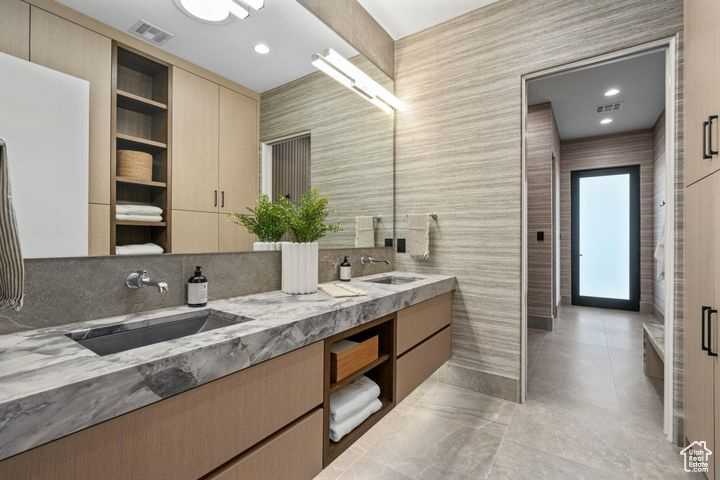 Bathroom with tile walls, vanity, and tile patterned flooring