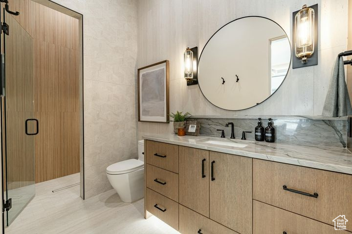 Bathroom with vanity, tasteful backsplash, toilet, and walk in shower