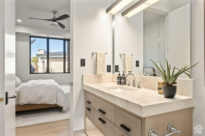 Bathroom with wood-type flooring, ceiling fan, and vanity