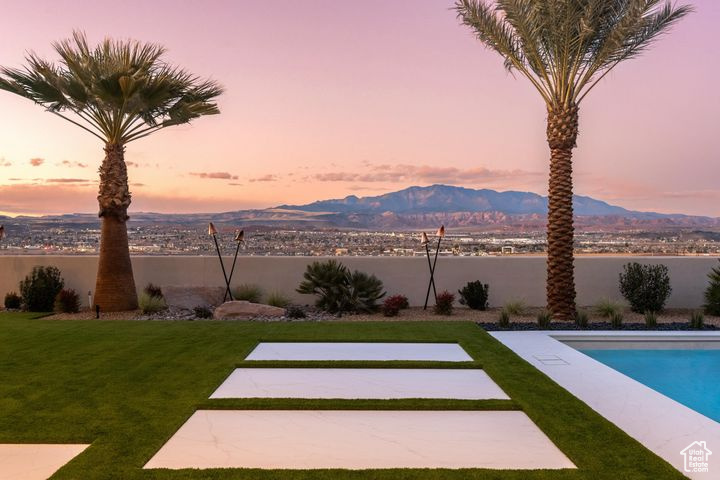 Yard at dusk featuring a fenced in pool and a water and mountain view