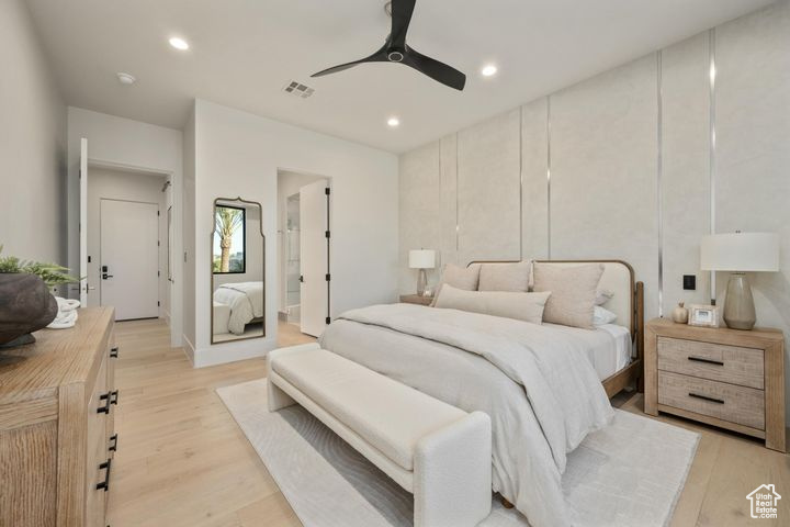 Bedroom featuring light wood-type flooring, ensuite bathroom, and ceiling fan