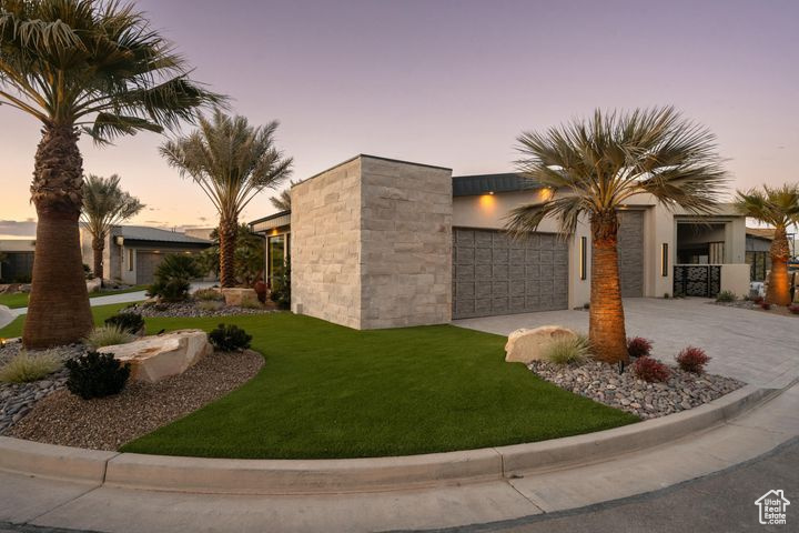 View of front of home with a garage and a yard